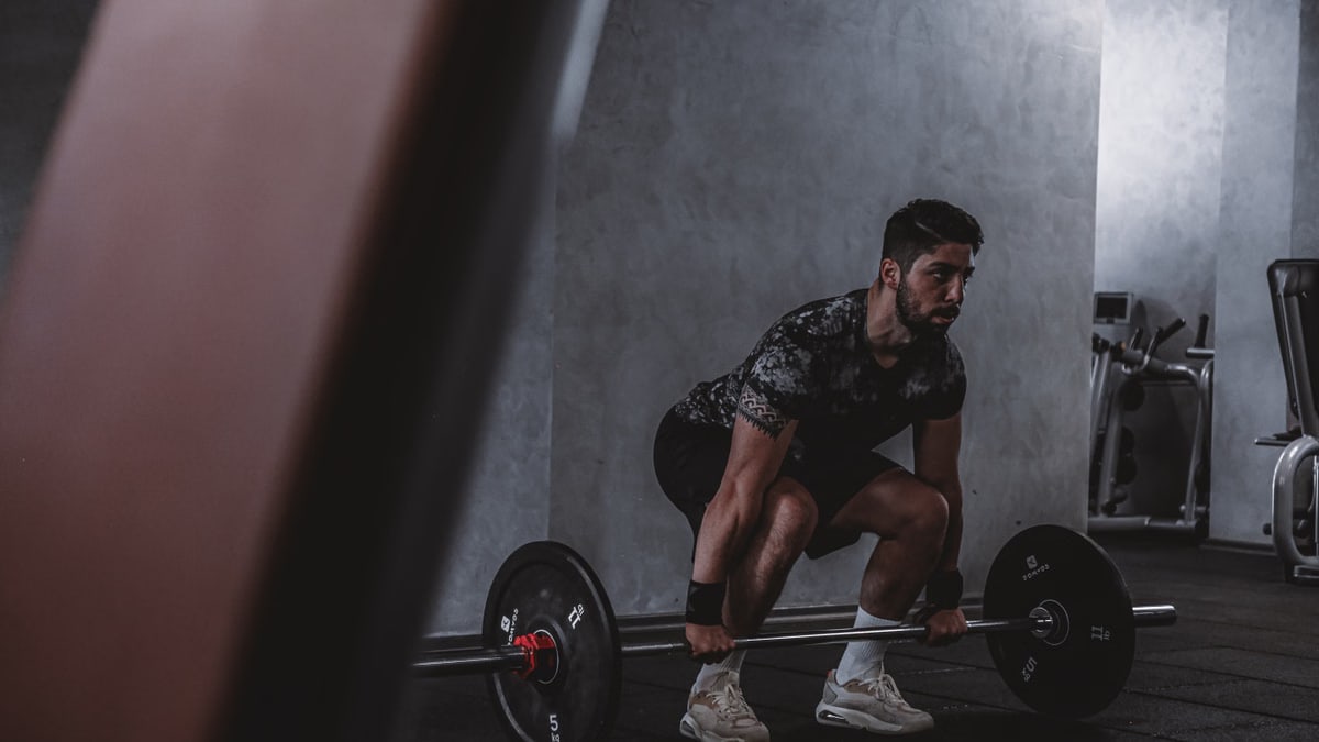 Man lifting weights in gym, displaying strength and focus. Ideal for fitness and training themes.